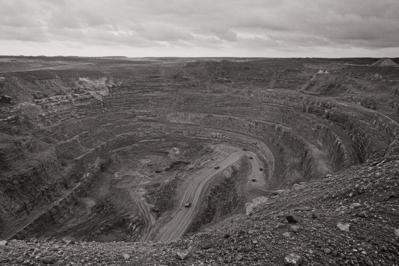 An open-pit mine with terraced benches cut into exposed rock